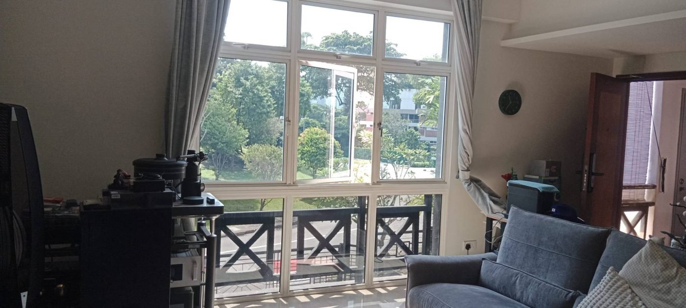 Living room window with Sunolite CF9050 film overlooking a balcony and greenery, showing daylight and outdoor view retained
